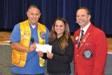 Janet Perez, form Hanford Boxing Club, accepts a check from Kings Lions President Roman Benitez and District Governor Al Kroell.